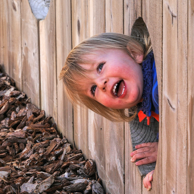 Pre-school child in a childminder setting enjoying and learning out of doors